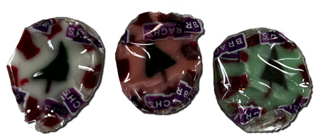 Three pieces of Brach's Christmas Nougats candy individually wrapped